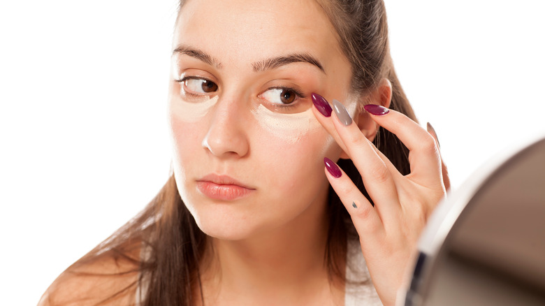 Woman applying undereye concealer