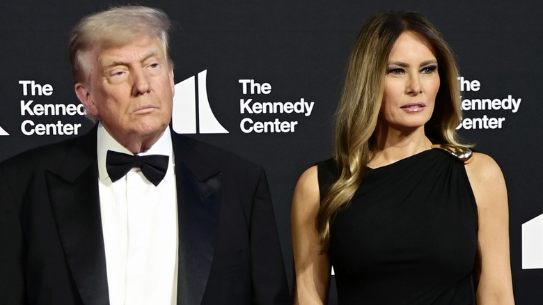 Donald Trump wearing a suit and bowtie next to Melania Trump who's wearing a black dress at the premiere of 'Les MIserables.'
