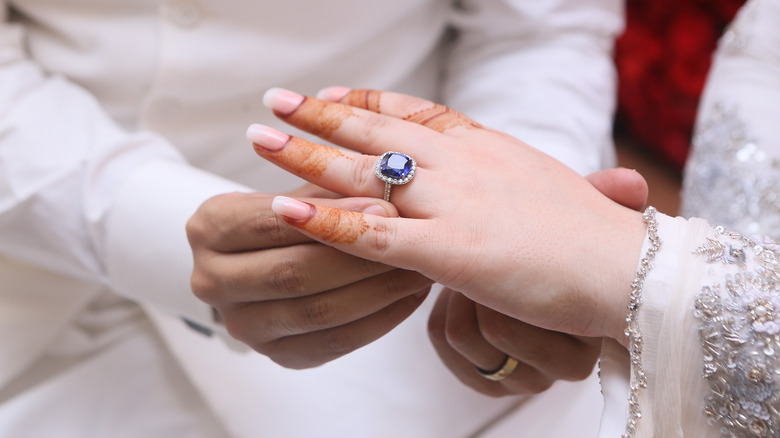 groom placing blue ring on bride