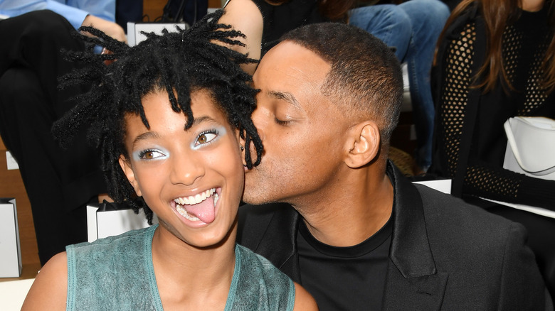 Will Smith kisses daughter Willow Smith at an event