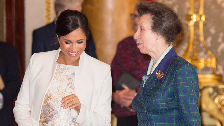 Meghan Markle laughing with Princess Anne at an event