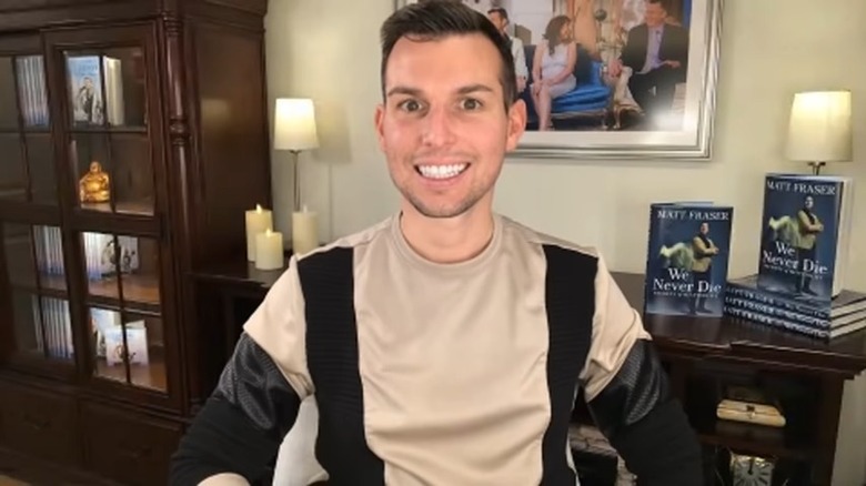 Matt Fraser smiling in front of book display