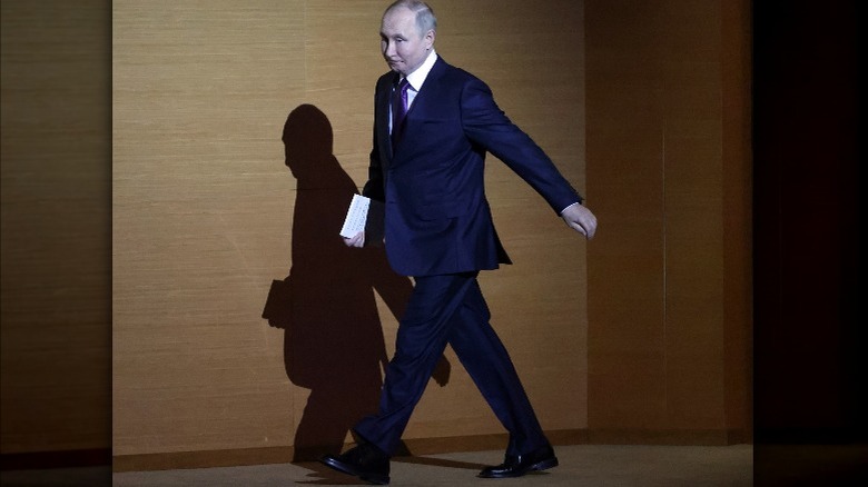 Vladimir Putin walking across a stage