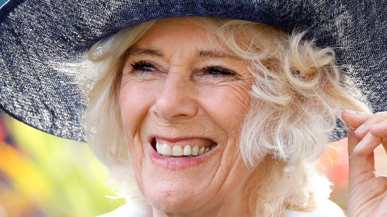 Queen Camilla smiling in hat