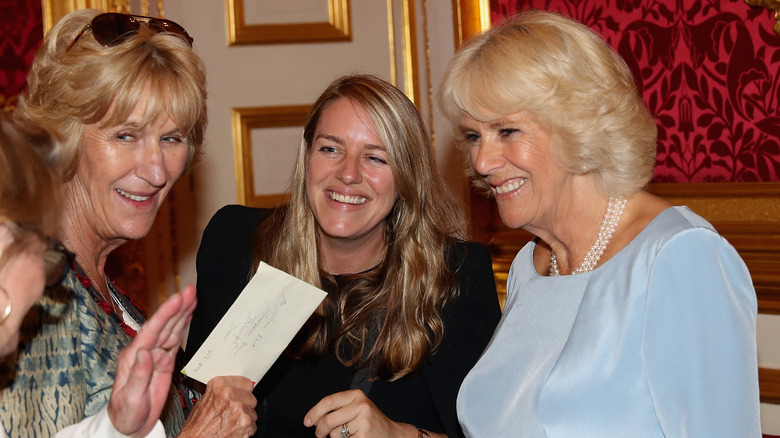 Queen Camilla laughing with Laura Lopes, Annabel Elliot