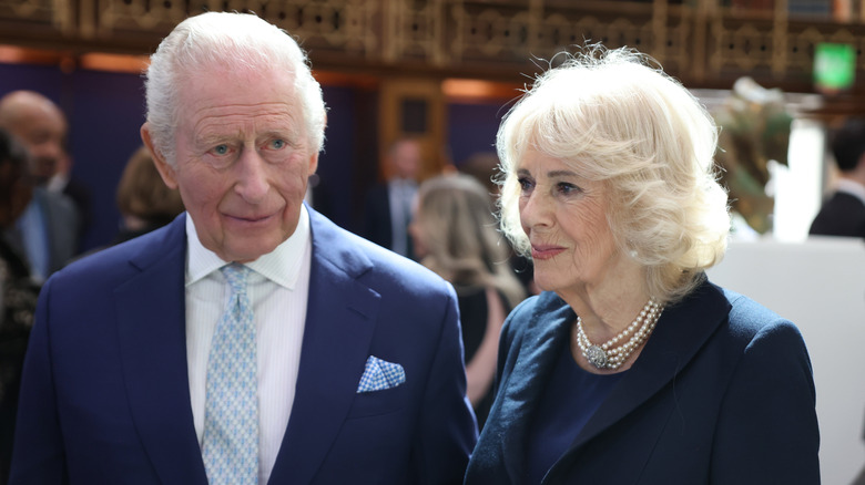 King Charles III and Queen Camilla smiling in blue ensembles.