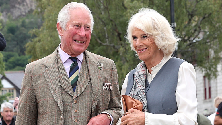 King Charles and Queen Camilla outdoors smiling