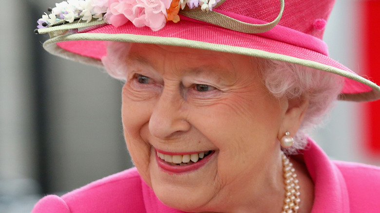 Queen Elizabeth II smiling in pink