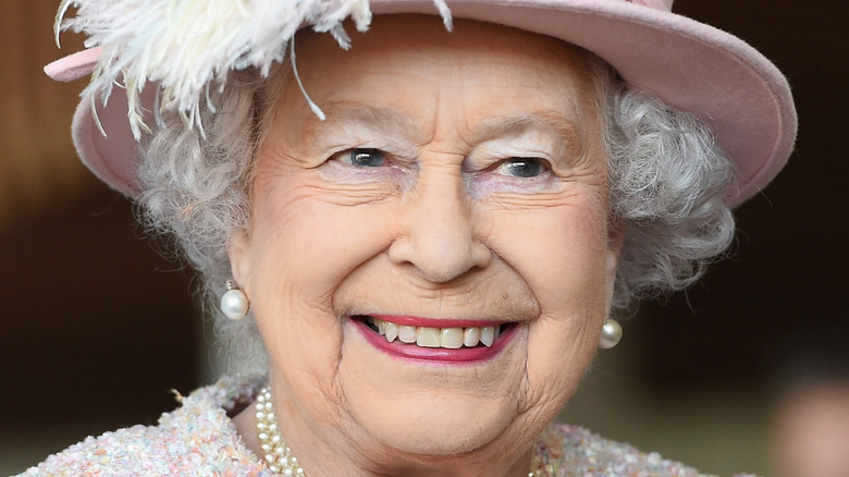 Queen Elizabeth smiling in a hat