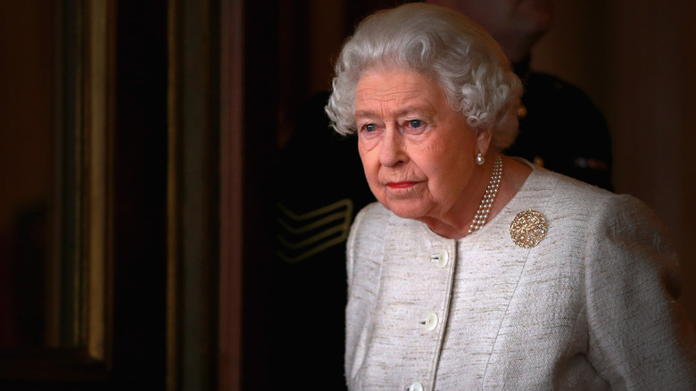 Queen Elizabeth in gray jacket looking concerned