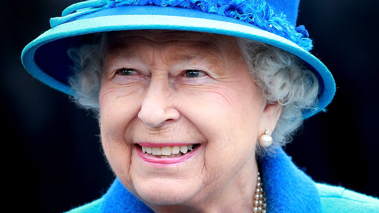 Queen Elizabeth wearing a light and dark blue hat