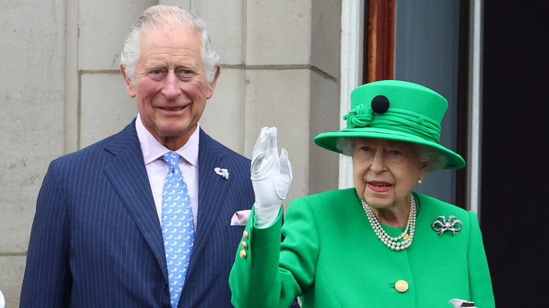 King Charles smiling with Queen Elizabeth smiling and waving