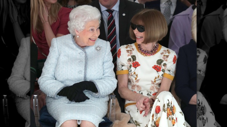 Queen Elizabeth II sitting with Anna Wintour at a runway show in 2018