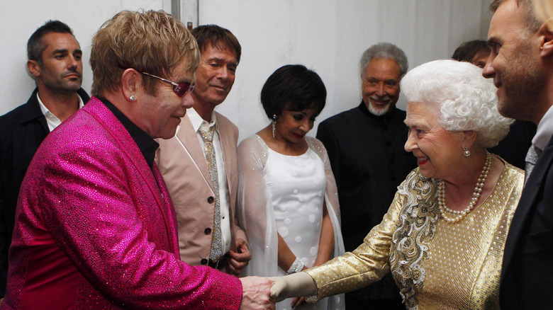 Elton John and Queen Elizabeth II shaking hands backstage at the Diamond Jubilee performance in 2012