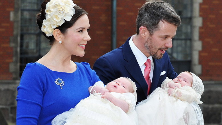 Princess Mary and Prince Frederik X hold their baby twins at their christening in 2011