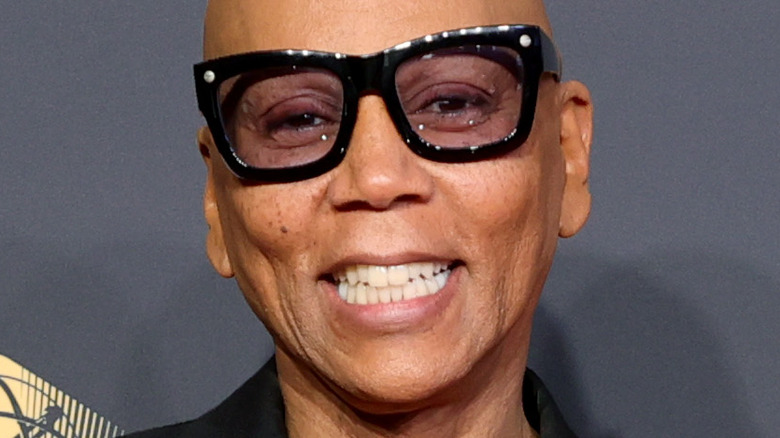 RuPaul Charles smiling and wering tinted glasses