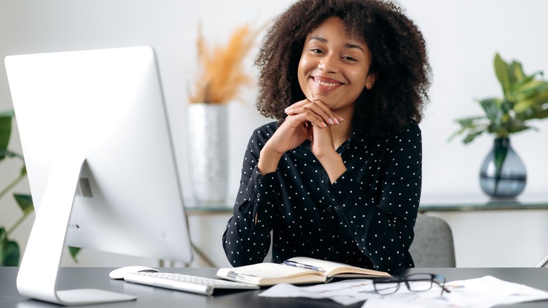 Woman smiling while working at her desk