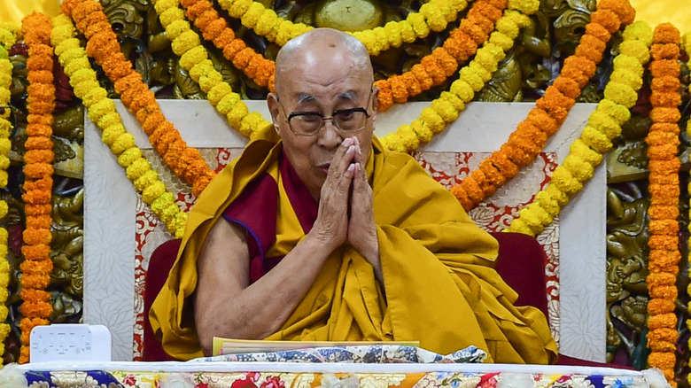 The Dalai Lama praying