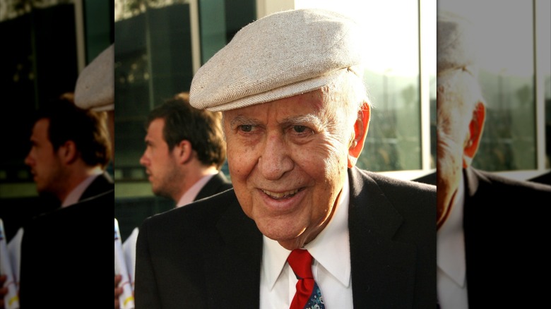 Carl Reiner smiling in a suit and hat