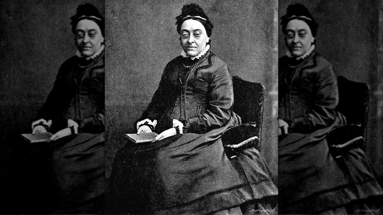 Christina Rossetti sitting with book