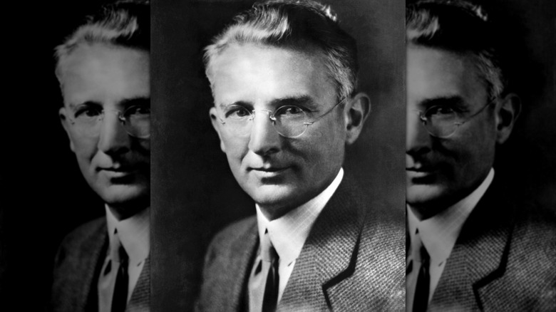A black and white portrait of Dale Carnegie in a suit with glasses