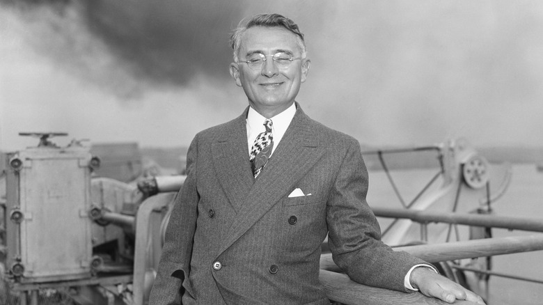 Dale Carnegie smiling in a suit while being photographed in 1938