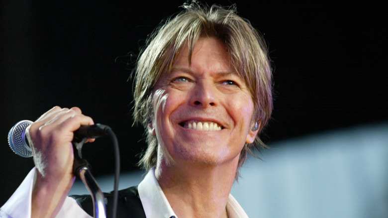 David Bowie smiling and holding microphone