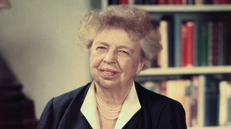 Eleanor Roosevelt smiling in front of book shelf