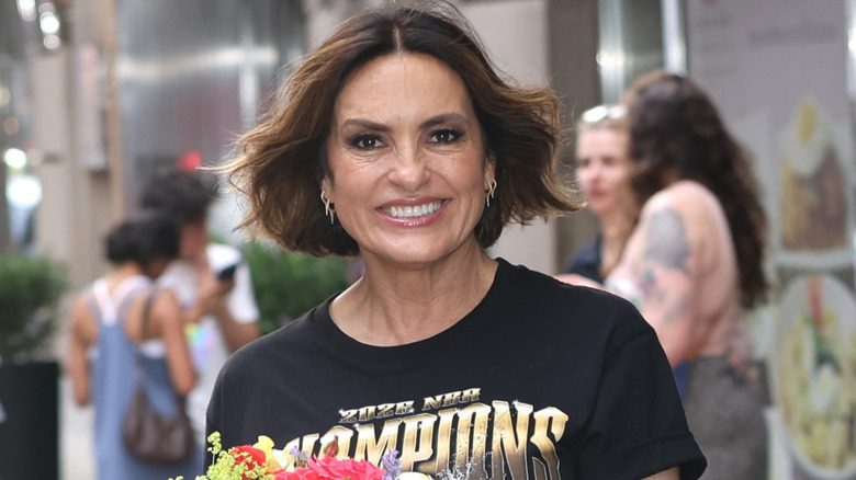 Mariska Hargitay in black Knicks T-shirt holding flowers