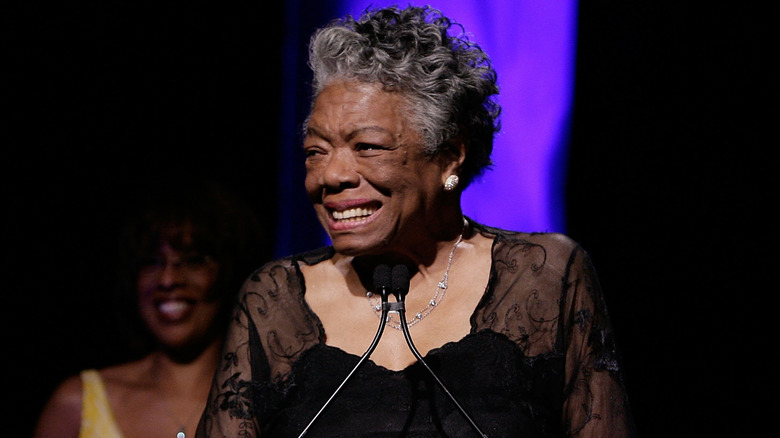 Maya Angelou smiling and talking at a microphone