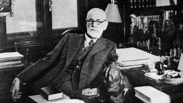 Black and white photo of Sigmund Freud sitting at a desk