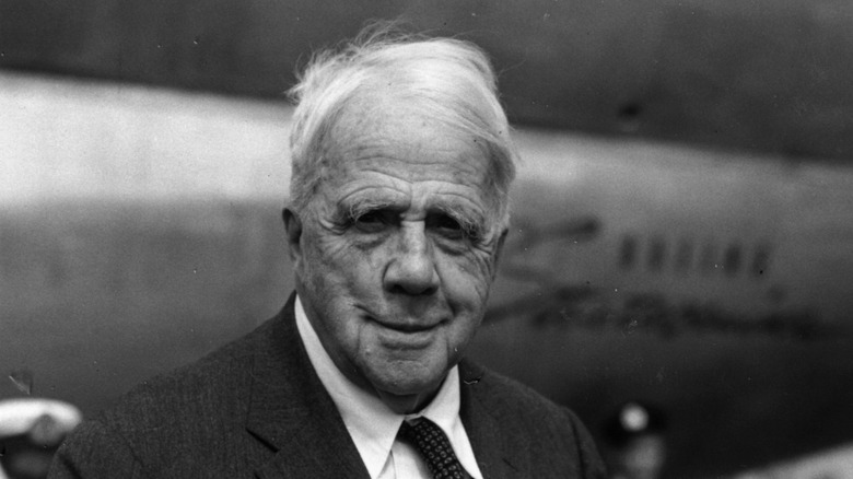 Robert Frost arriving at an airport in London in a dark suit
