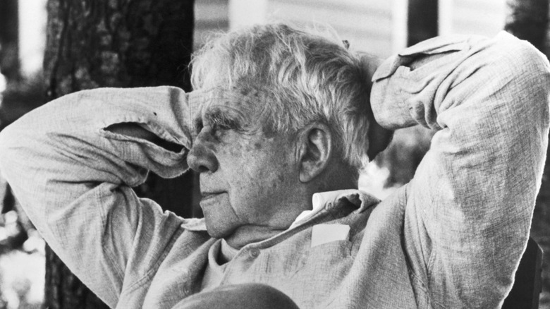 Robert Frost leaning with his hands behind his head, elbows up
