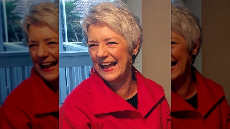 Sue Monk Kidd in red jacket laughing