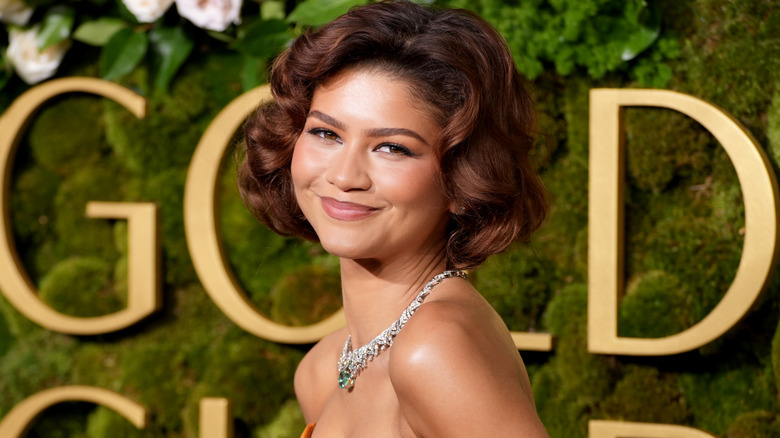 Closeup of Zendaya wearing an orange gown and sparkling necklace