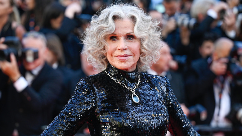 Jane Fonda smiling while posing in a sparkly black dress
