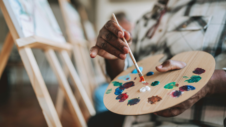 A close-up of an artist using a paint palette