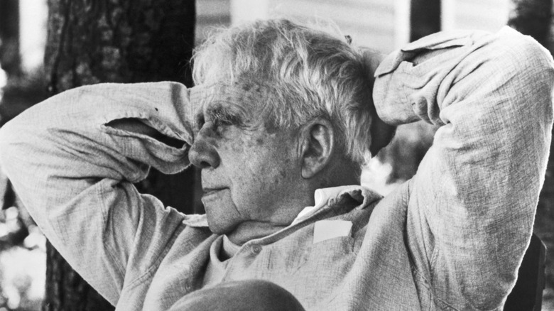 Robert Frost with his hands behind his head