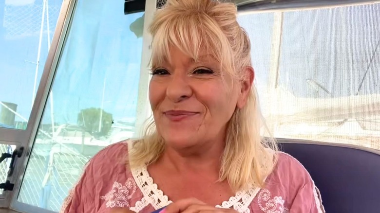 Antonella Nester in a pink embroidered top smiling inside a boat cabin.