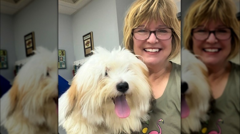 Carolyn Gracie smiling with a dog in her arms.