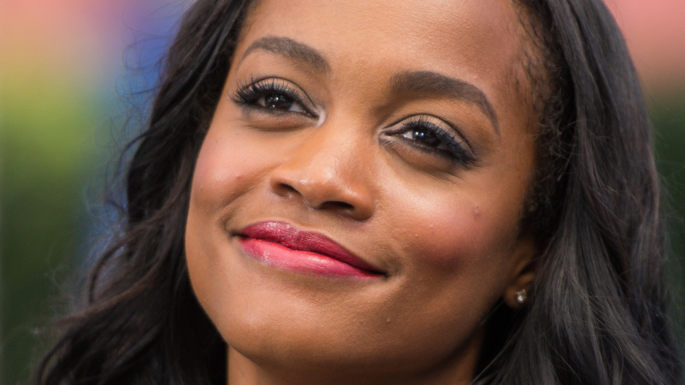 Rachel Lindsay smiles and wears red lipstick