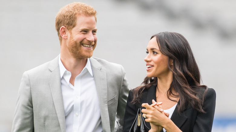 Prince Harry and Meghan Markle sharing a laugh while walking together