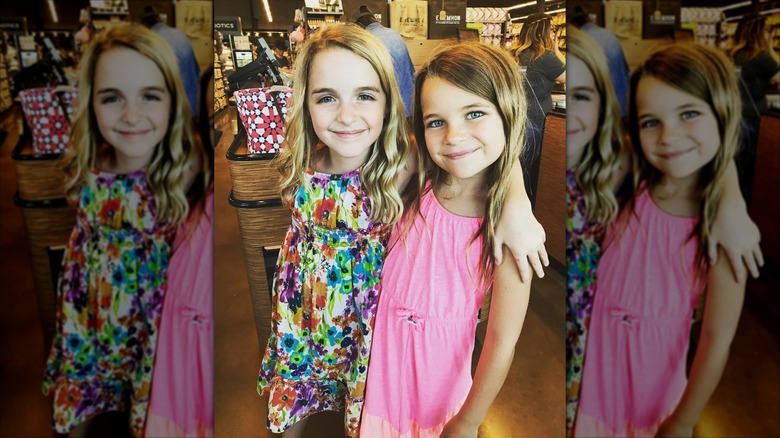 Young Ragean Revord inside a grocery store has her arm slung around young McKenna Grace.