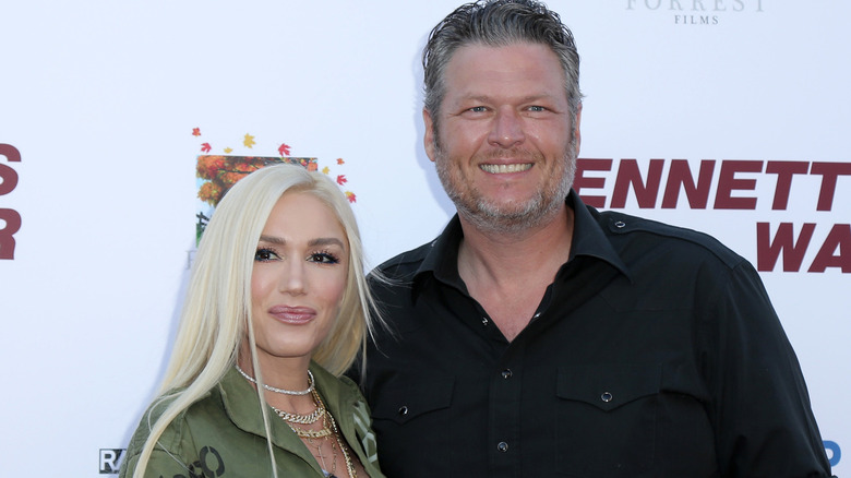 Blake Shelton and Gwen Stefani smiling together at an event