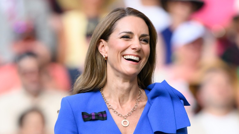 Kate Middleton smiling and laughing in a blue dress at Wimbledon 2025