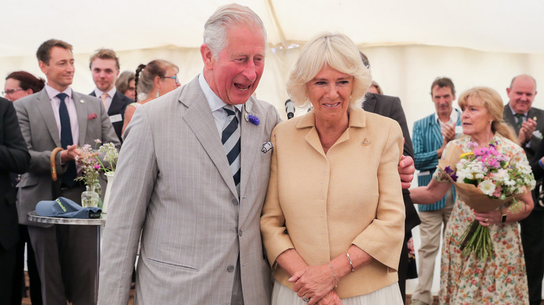 King Charles with arm around Queen Camilla