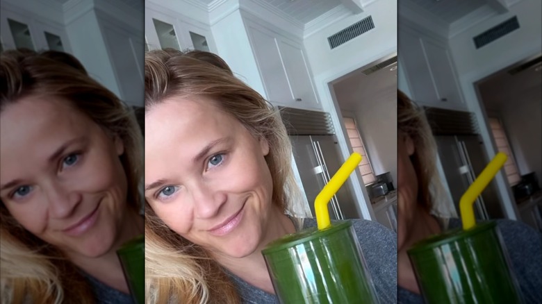 Reese Witherspoon smiling with a smoothie