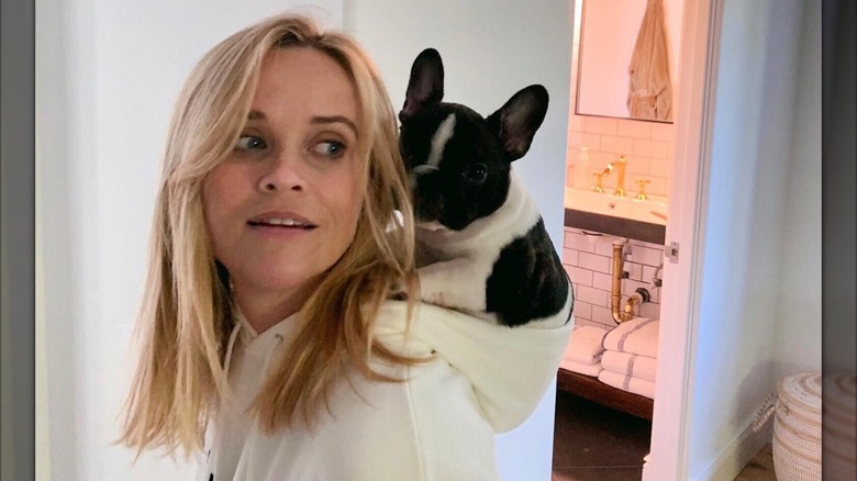 Reese Witherspoon with a puppy on her back