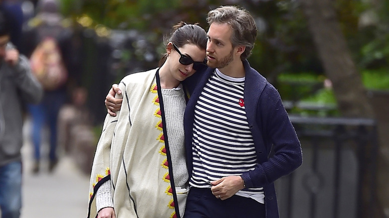 Adam Shulman wraps his arm around Anne Hathaway