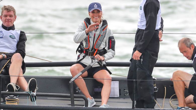 Catherine, Princess of Wales smiling and waving while sitting on a boat